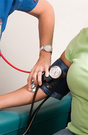 Eine Ärztin misst den Blutdruck einer Patientin